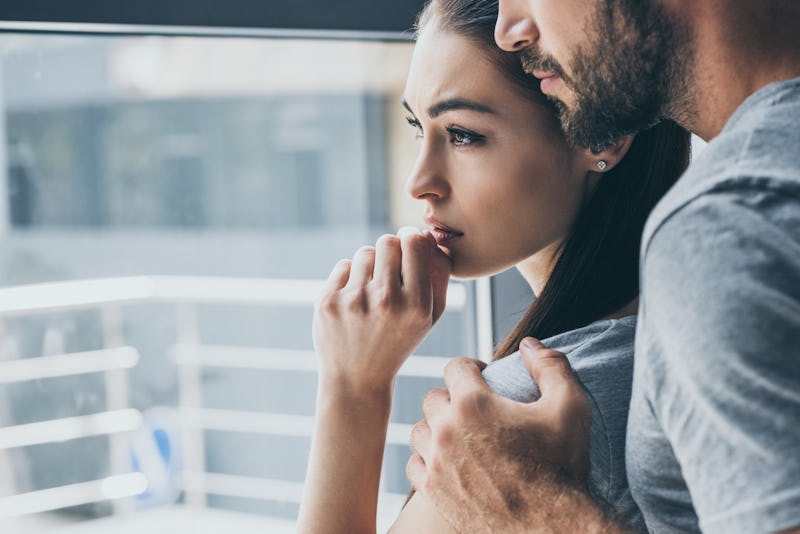 cropped shot of bearded man supporting sad young woman looking at window