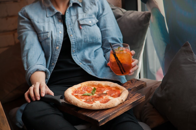 Woman with pizza and coctail