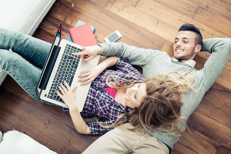 Couple shopping online at laptop computer - Two young friends watching a video on a notebook in the ...