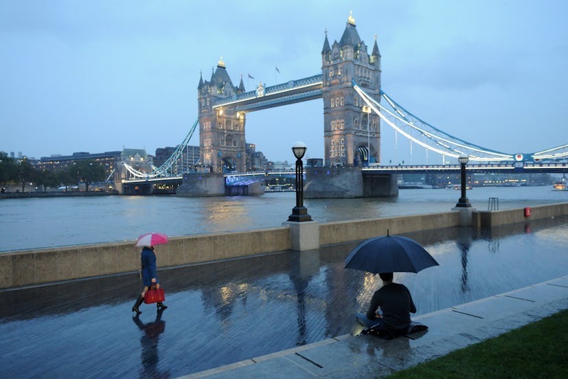 Tower Bridge people with umbrellas in London, United Kingdom