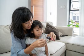 asian mother giving her daughter a medicine at home