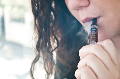 woman with e-cigarette on rust background
