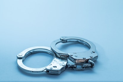 Handcuffs with signs of usage on blue background