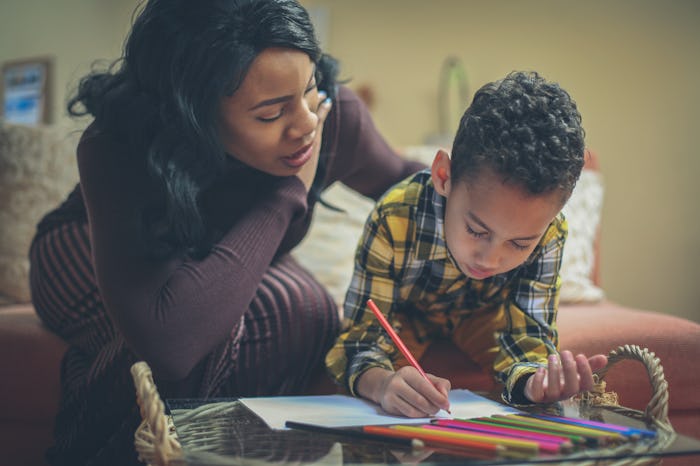 Preschool boy with his mother doing homework.