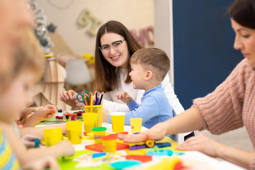 Preschool kids sticking with plasticine in classroom in kindergarten