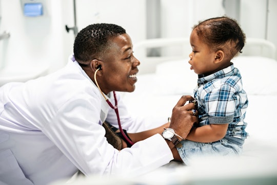 Cheerful pediatrician doing a medical checkup of a young boy