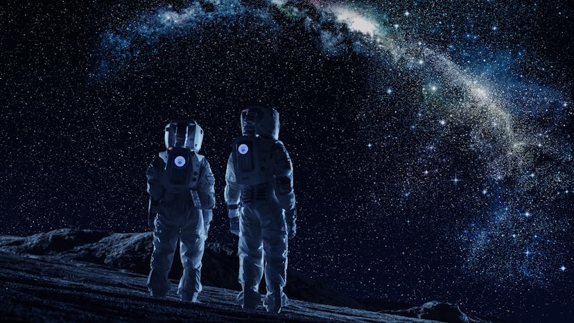 Crew of Two Astronauts in Space Suits Standing on the Moon Looking at the The Milky Way Galaxy. High...