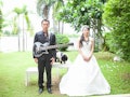 Bride and groom is happy play guitar in the lawn with dog