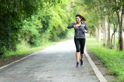 Running woman. Sport Women jogging during and check timing.  Outdoor Workout in a Park. Weight Loss ...