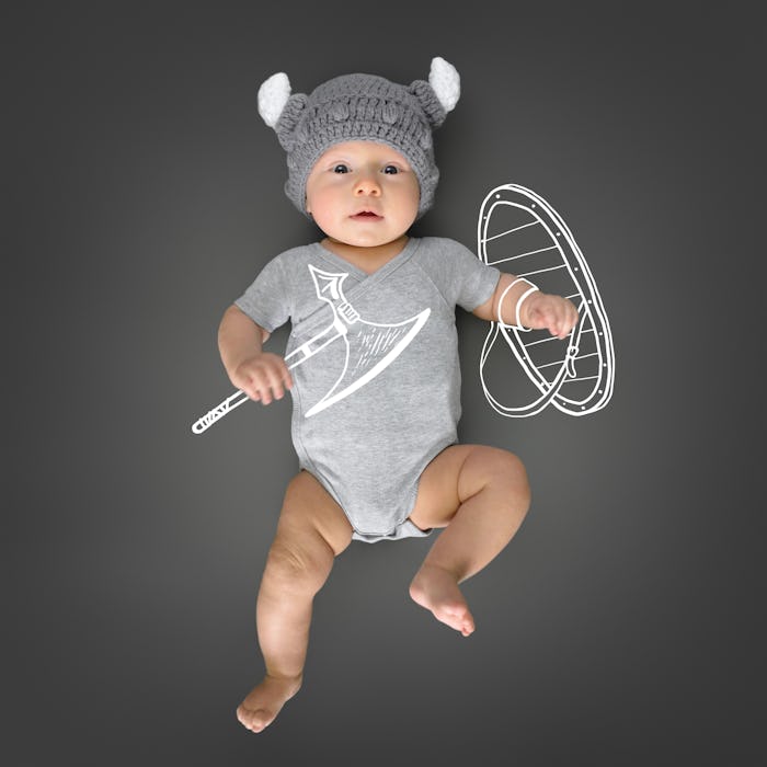 Three month old baby in viking's hat lying on a play mat and pretending he is a real viking warrior