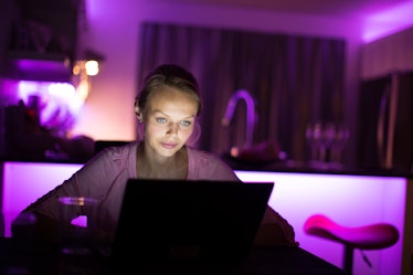 Pretty, young woman burning the midnight oil - staying up late do get some work done (color toned im...