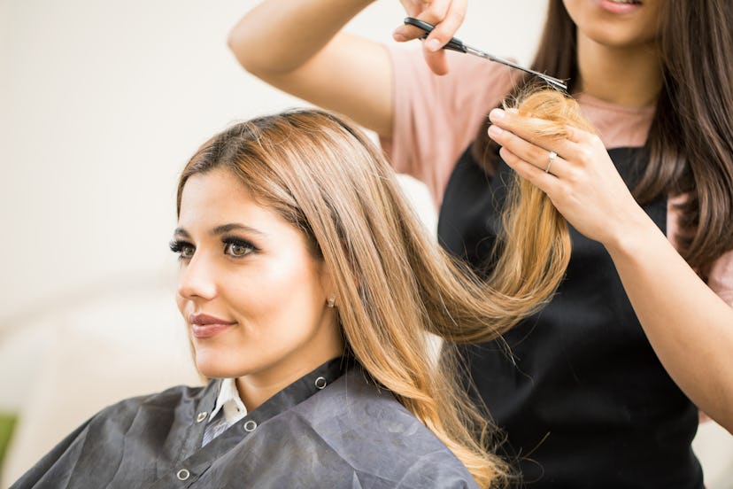 Portrait of a gorgeous young blonde getting her hair cut by a hairstylist at a beauty salon