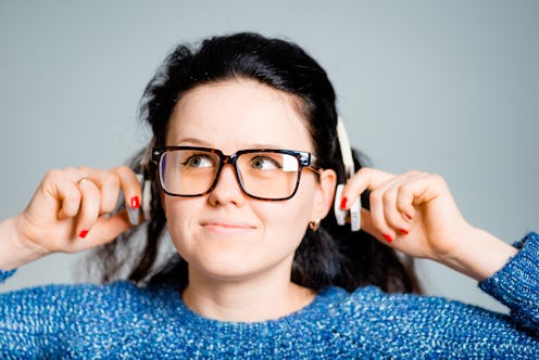 business woman listening to wireless headphones isolated on gray background