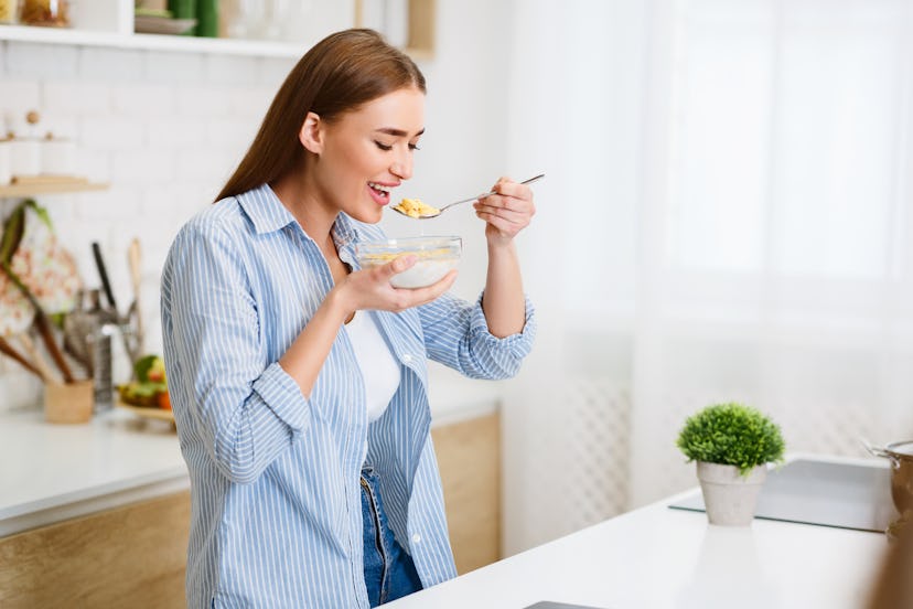 Healthy Eating. Woman Eating Corn Flakes Having Breakfast In Kitchen