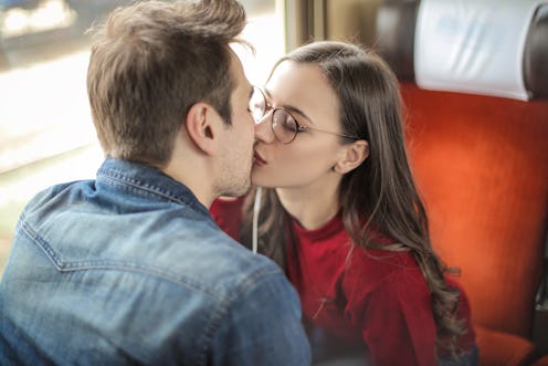 Couple kissing in a train, while listening music from the same headphones