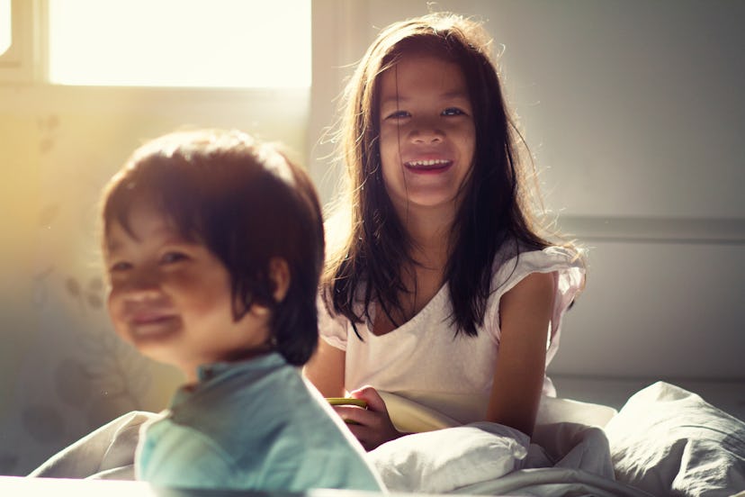 Soft focus image of Kids in their bedroom.The warm climate of Asian mixed race sibling wake up in th...
