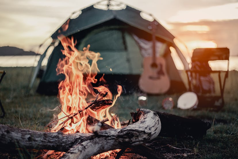 Group of friends camping.They are sitting around fire camp.