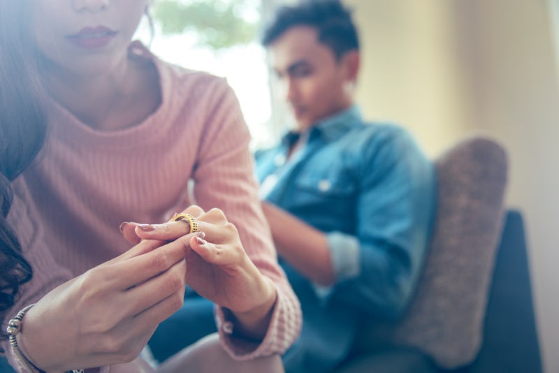 Close-up of a Sad Wife want to Divorce Lamenting Holding the Wedding Ring in a House Interior with B...