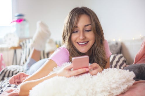 Portrait of a beautiful young millennial girl in her bedroom using phone and hanging out with her gr...