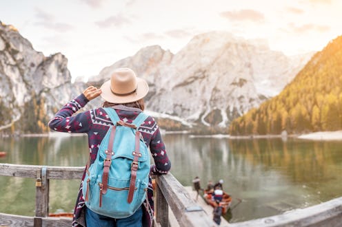 Asian woman traveler on the shore of the famous tourist lake Braies in the Dolomites Alps, Italy. Th...