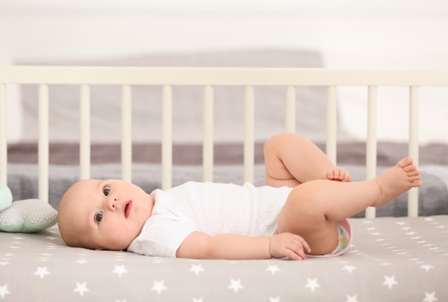 Cute baby lying in crib at home