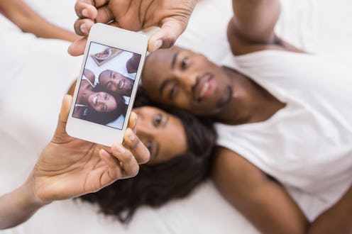 Young couple taking a selfie in their bedroom