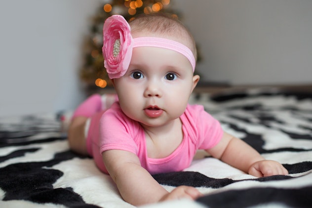 baby infant playing at home. toys plush bears around. smiling child