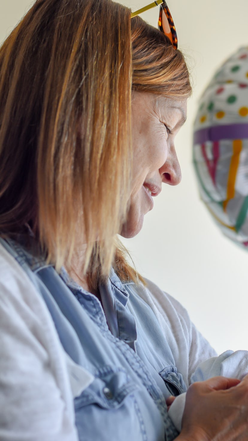 woman cuddling newborn baby in hospital