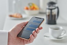 Close Up Detail Of A Man Holding A Smartphone Over A Kitchen Counter