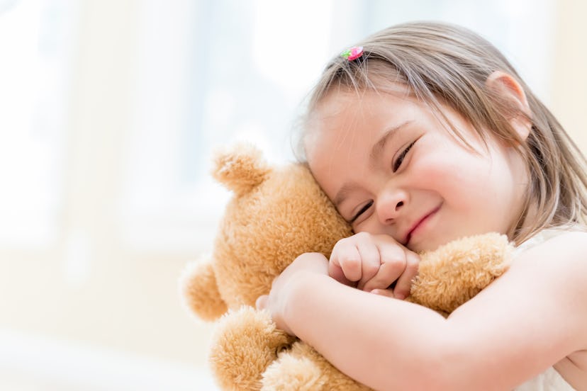 Little girl with teddy bear at home