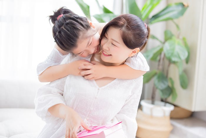 Daughter give mom a hug and mom smile happily