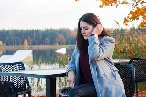 girl alone resting by the river in autumn on an autumn background