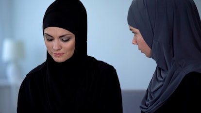 Arab woman talking with depressed friend, helping with life problems, advice