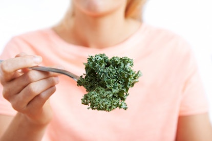Close Up Of Woman With Kale On Fork