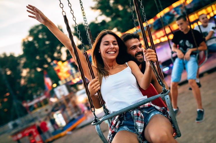Beautiful couple having fun at amusement park. Soft focus, high ISO, grainy image.