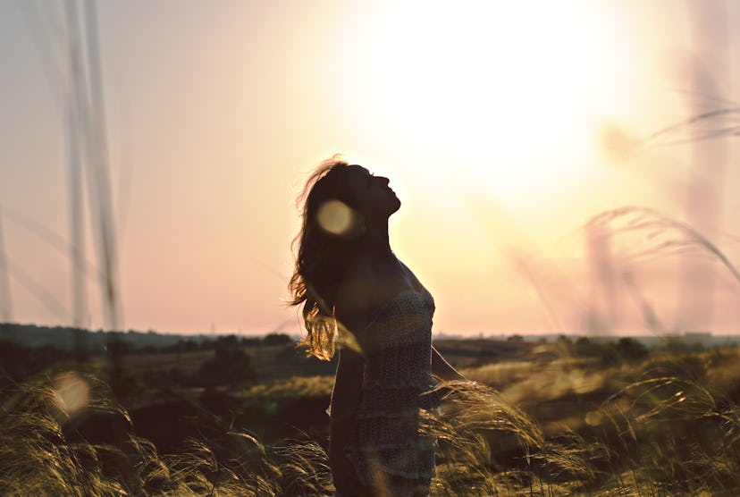 Silhouette of happy women  in grass field at sunset. Summer happiness