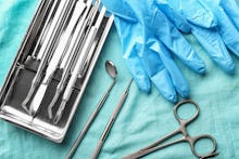 Tray with dentist's tools and gloves on fabric