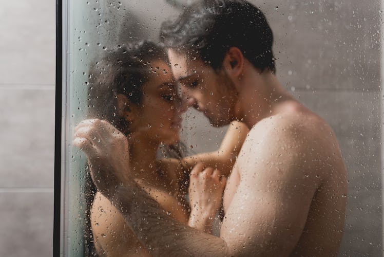 selective focus of sexy man and beautiful woman hugging in shower cabin