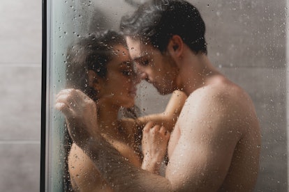 selective focus of sexy man and beautiful woman hugging in shower cabin 