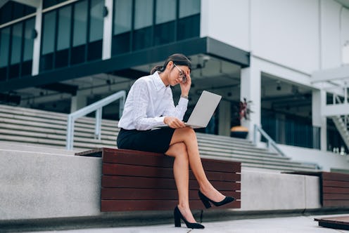 Asian businesswoman in eyeglasses using laptop working about business and finance feeling stressful-...