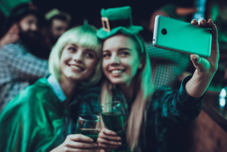 Two happy friends take a selfie at a bar on St. Patrick's Day.