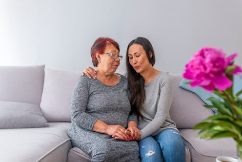 Love of mother and daughter. Smiling mother and daughter talking on couch at home. Asian Mother With...