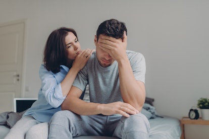 Attractive female consoles her sad boyfriend who has depression and some problems, pose at bedroom o...