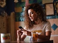 Young arabic woman with black curly hairstyle sitting in a beautiful bar with vintage decoration. Ar...