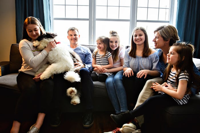A Portrait of nice cute cheerful big family parent with the twin girls and children with bobtail dog