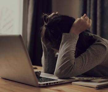 stress female student exhausted after finish homework with laptop and smart-phone and tablet and cr...