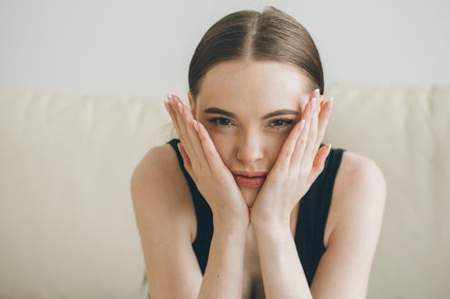 Stressed woman at home headache pain female portrait. Beautiful girl close face and head by hands si...