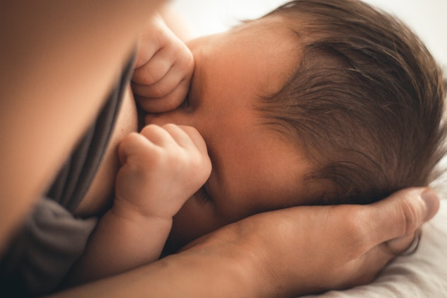 breastfeeding a sleeping baby in its mothers hands in the morning