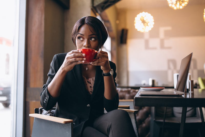 African american business woman drinking coffee in a bar