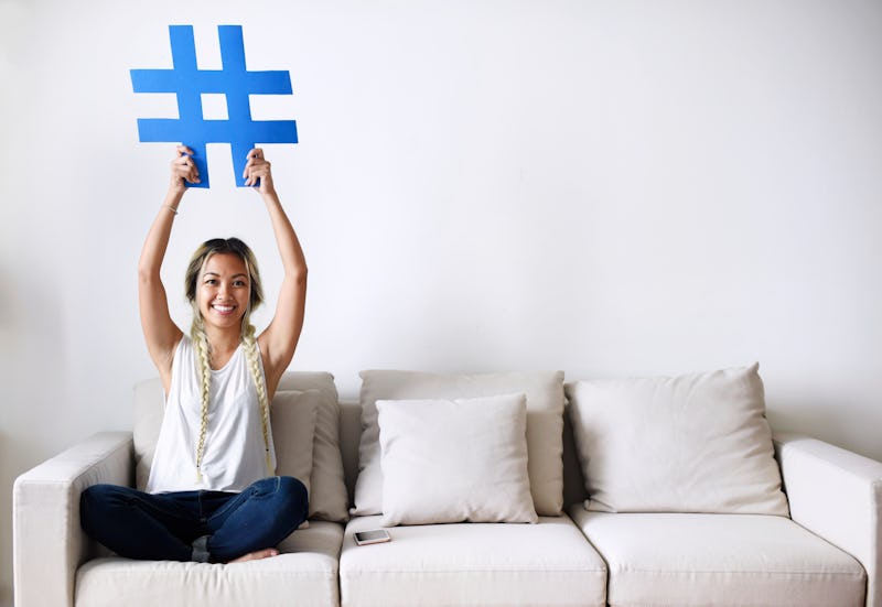 Smiling woman holding a hashtag sign social media concept